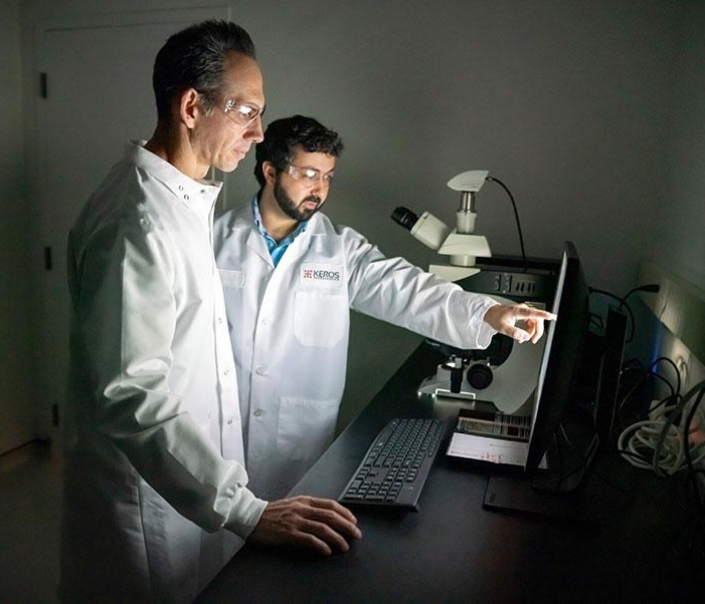 Two male Keros Therapeutics scientists reviewing data on a computer monitor
