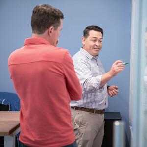 Keros employees collaborating on a white board