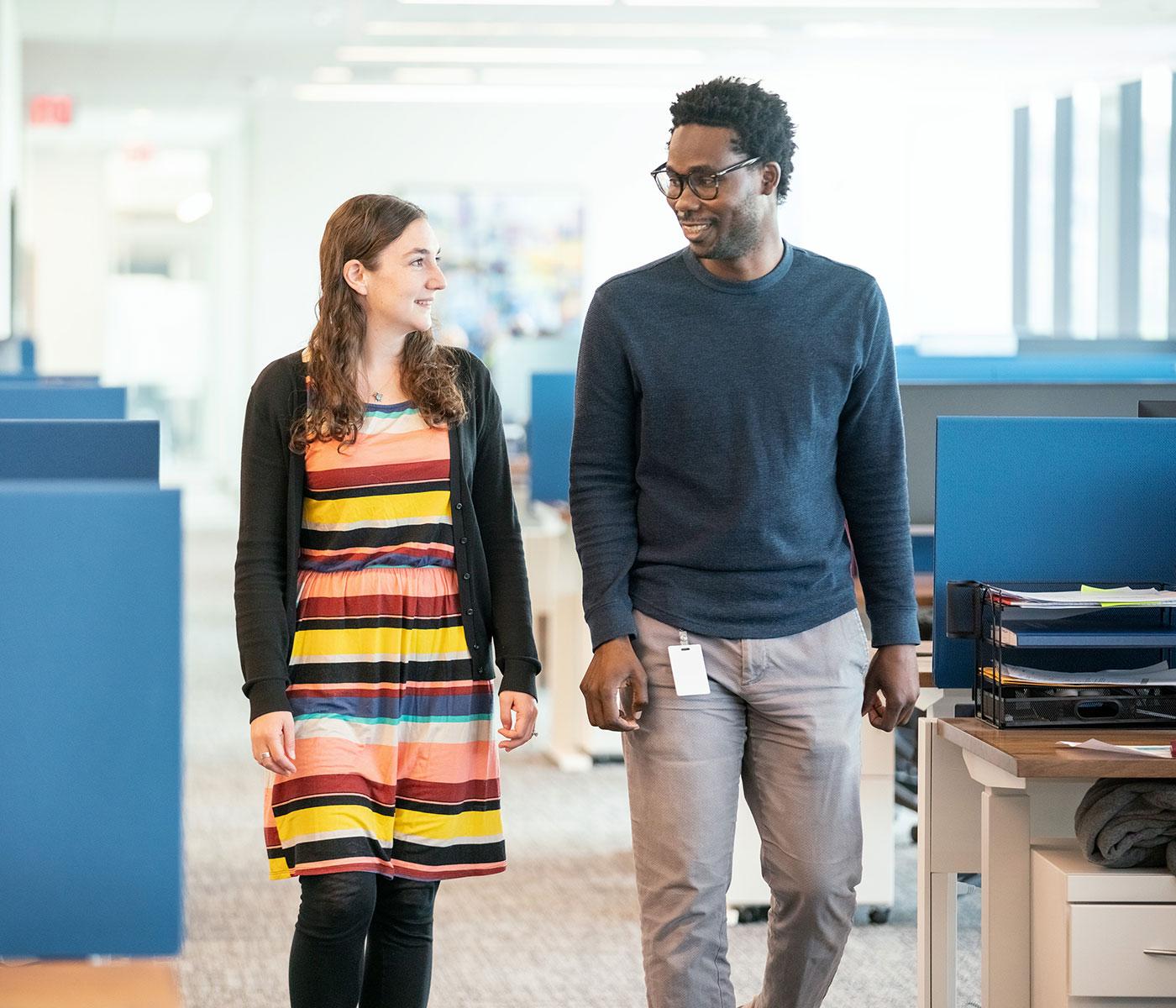 Two Keros Therapeutics smiling walking through the office.